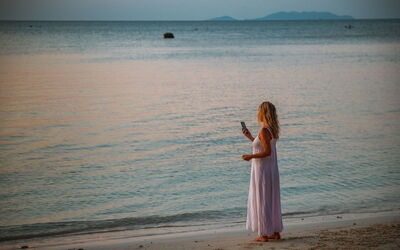Vrouw in telefoongesprek op strand